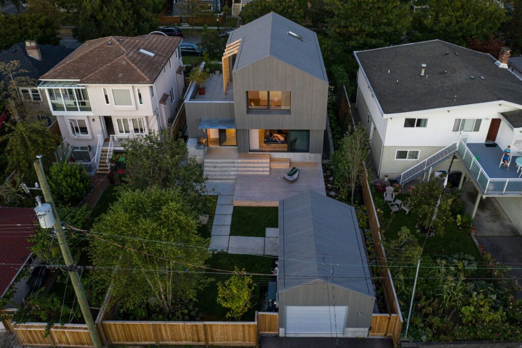 Aerial view of a wood-clad home and garage