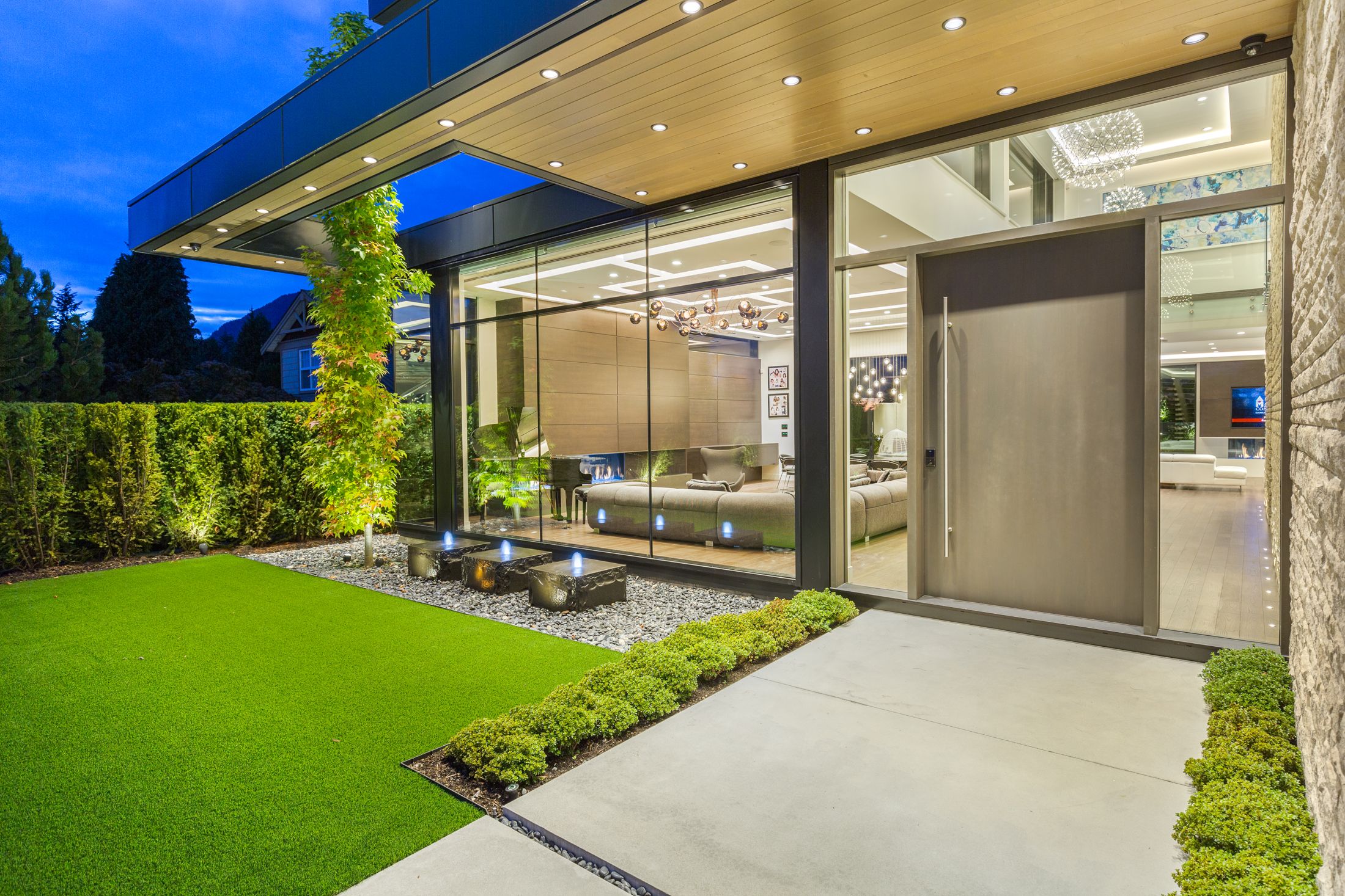 Wood soffit over a glass entry at dusk