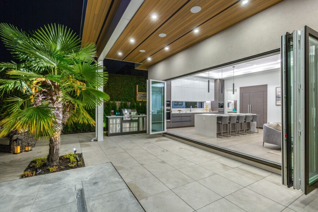 Wood soffit over an outdoor kitchen and folding glass wall